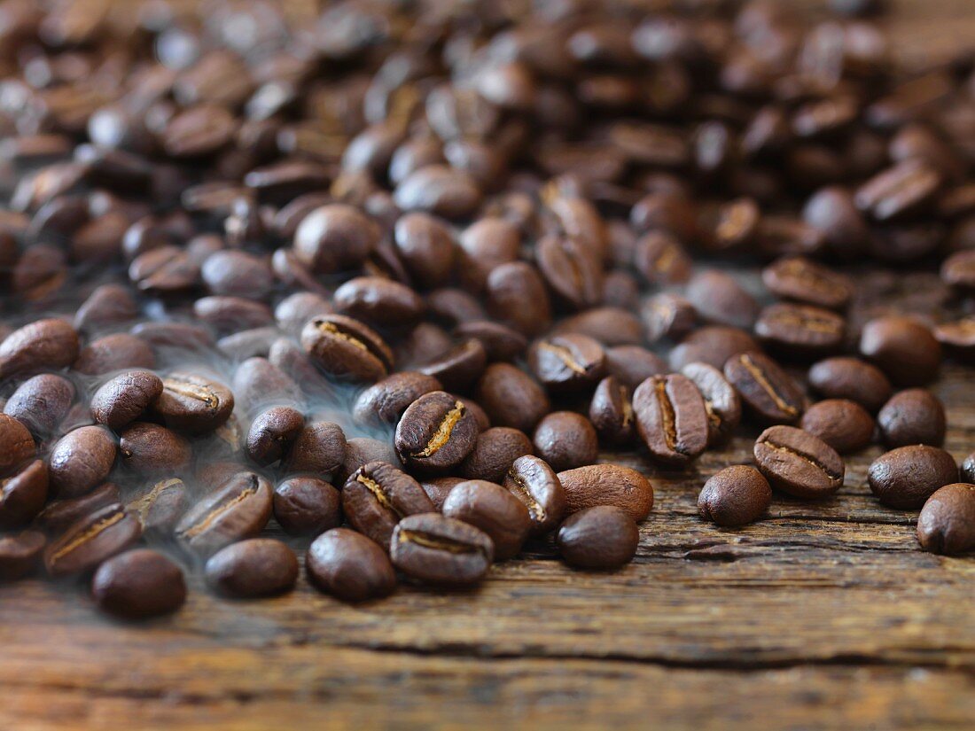 Viele Kaffeebohnen auf Holzuntergrund