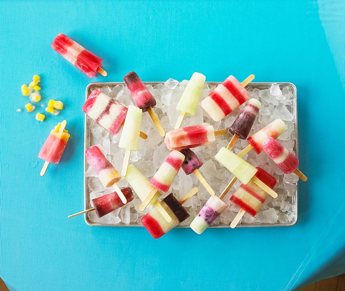 Homemade ice lollies on tray of ice cubes