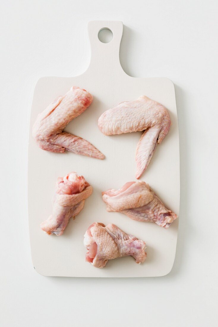 Chicken wings and legs on a chopping board