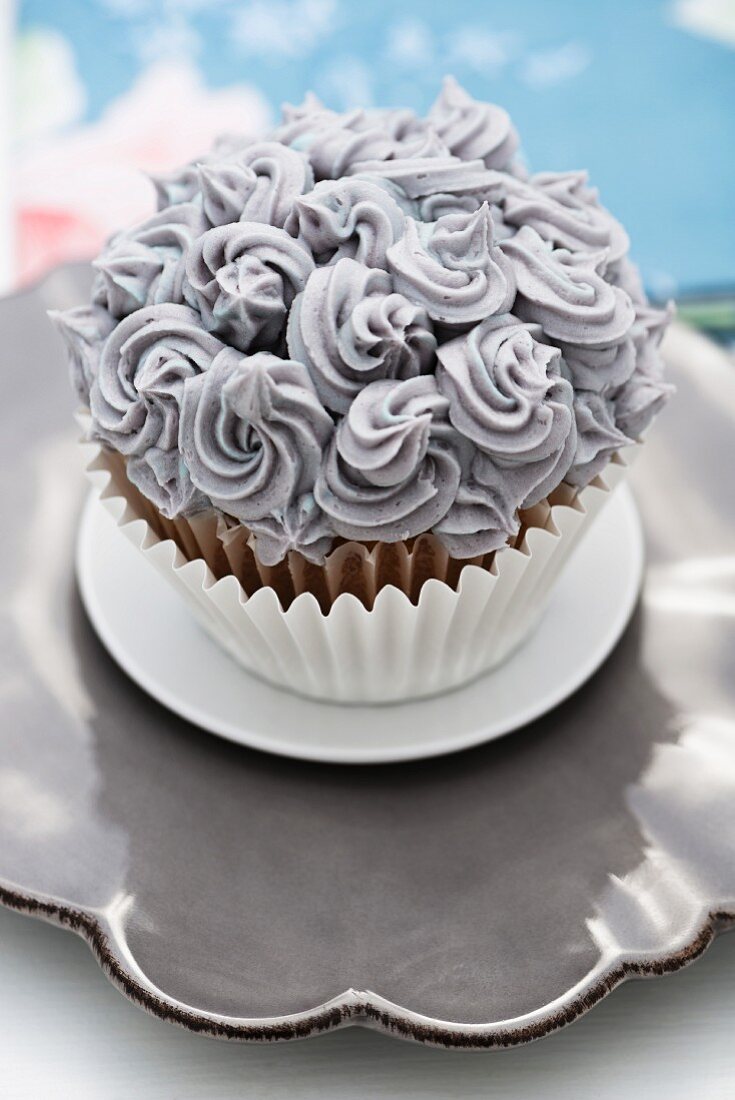 A cupcake decorated with grey buttercream
