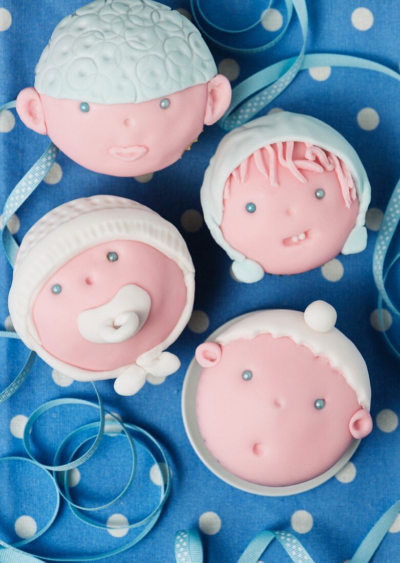 Cupcakes decorated with baby faces for a baby shower