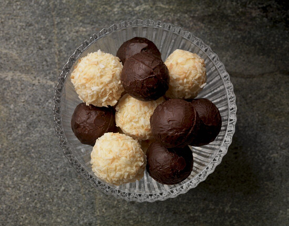 White and dark chocolate truffles in a glass bowl