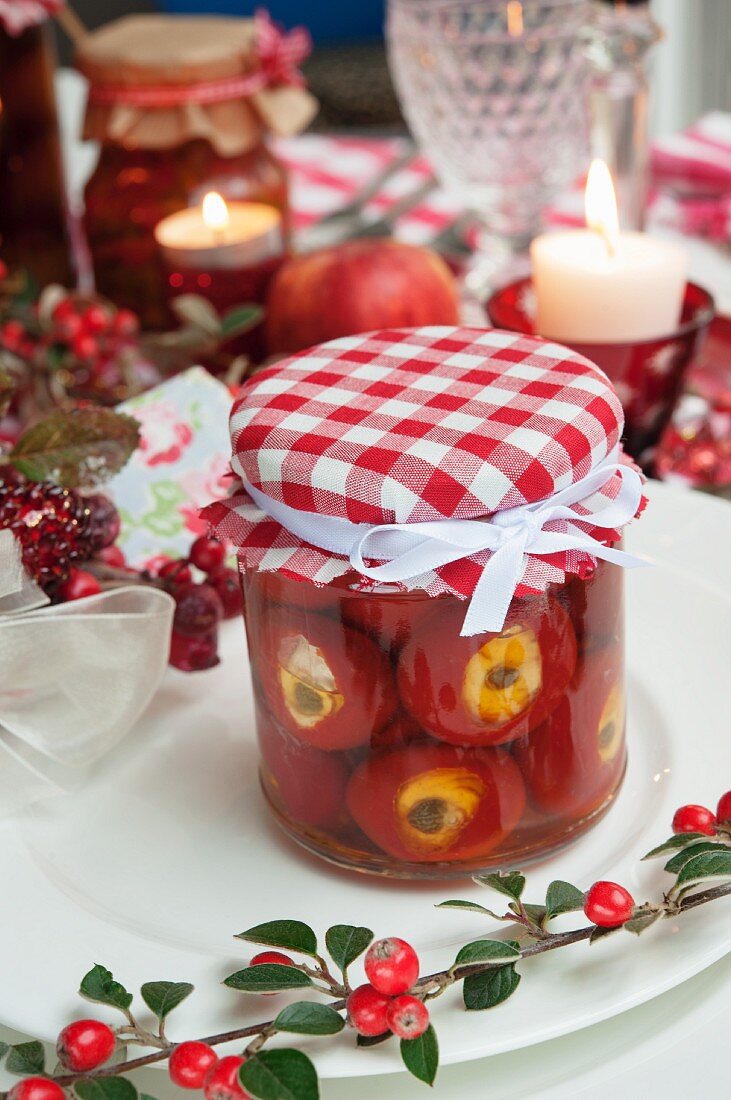 A jar of stuffed peppers with cream cheese on a table laid for Christmas