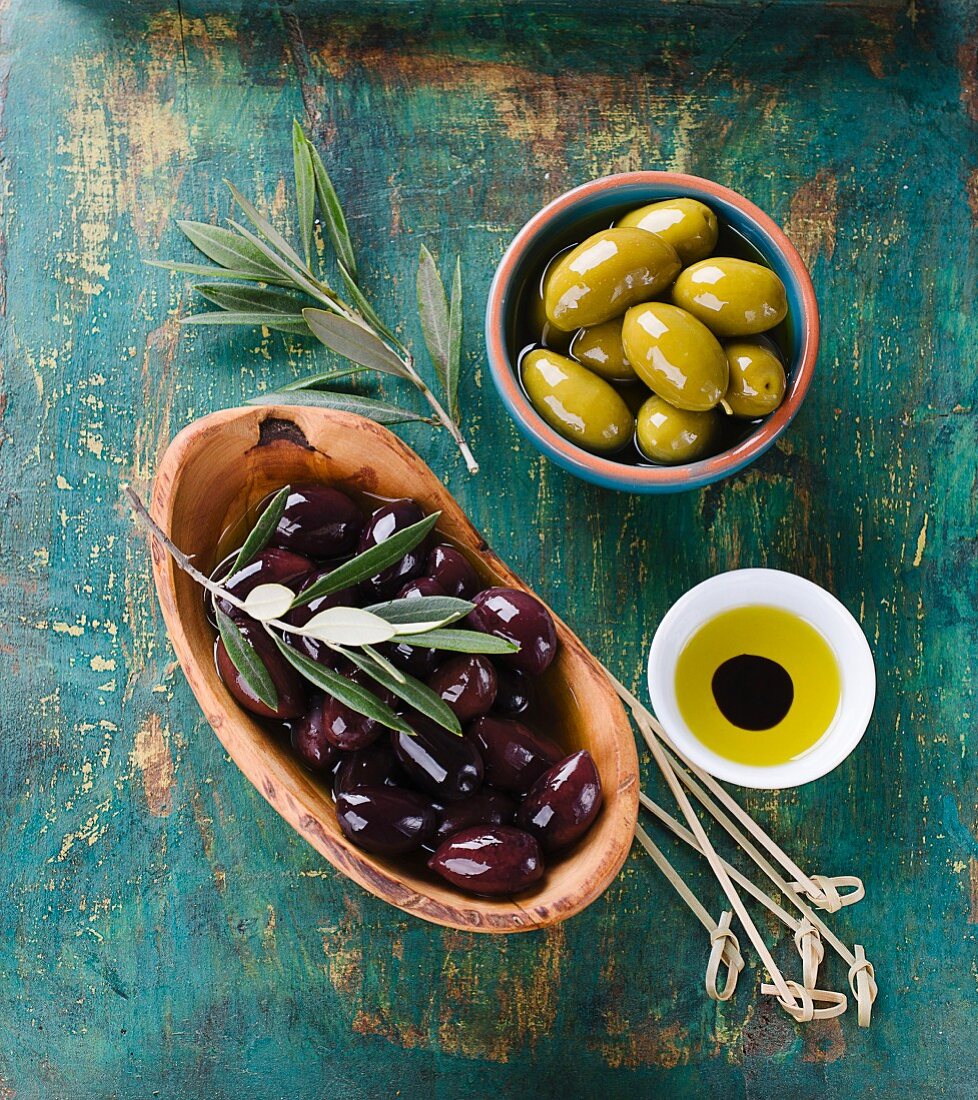 Schwarze und grüne Oliven mit Olivenöl