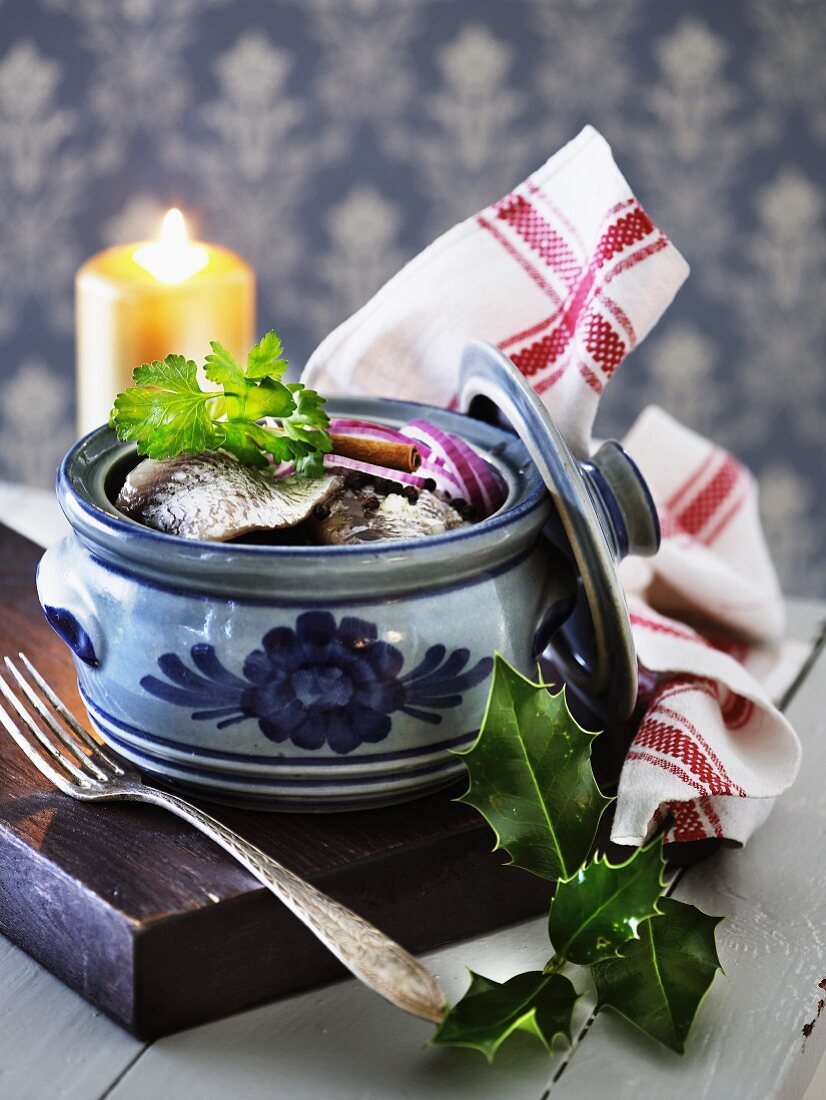 Herring fillets with onions in a ceramic pot (Scandinavia)