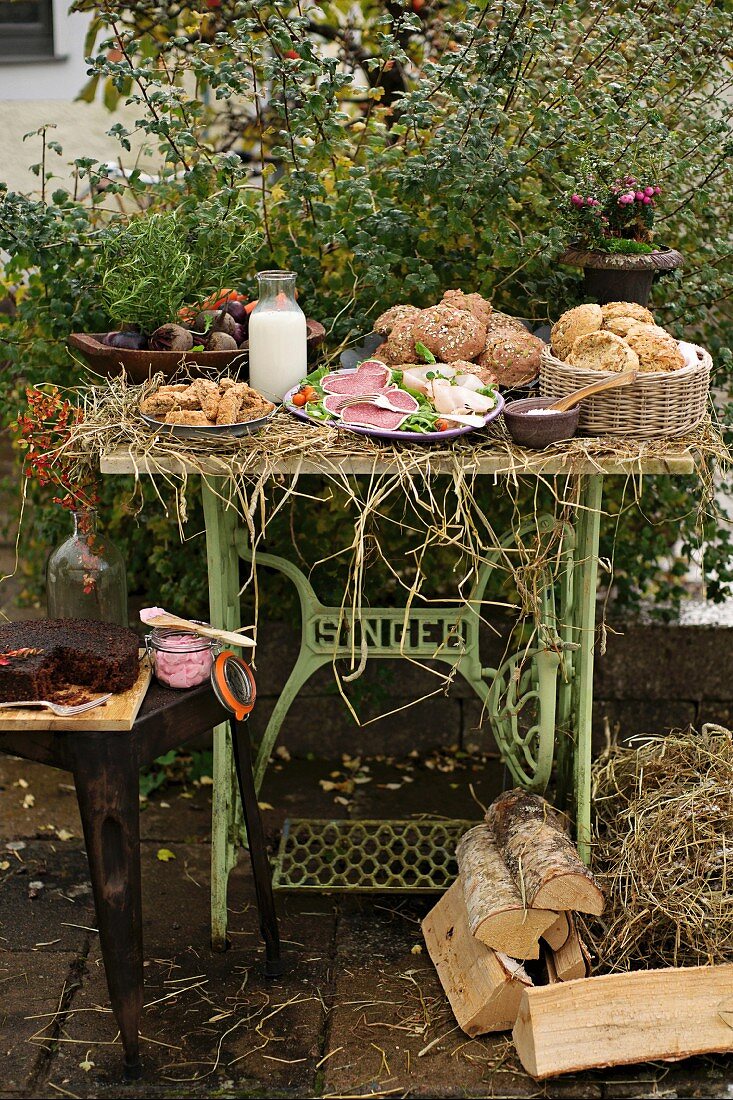 Herbstliches Buffet mit Brötchen, Wurst und Kuchen im Garten