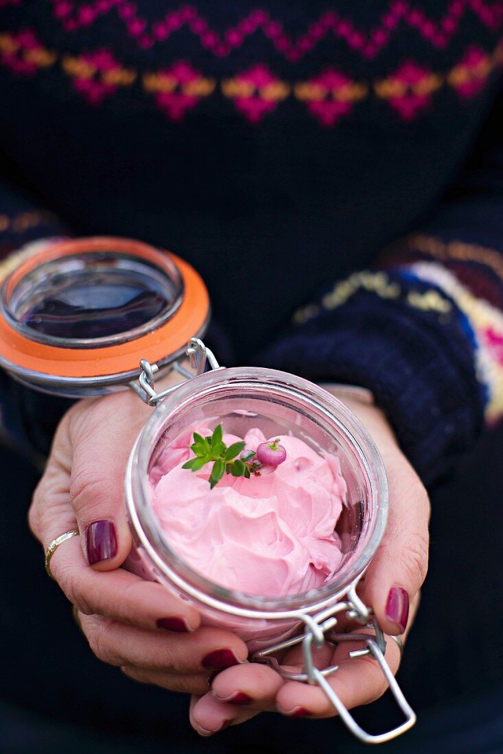A woman holding a jar of beetroot cream cheese