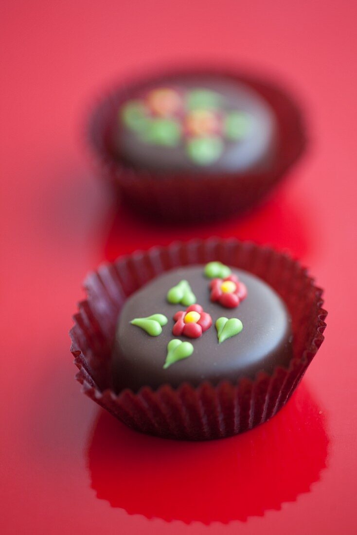 Two chocolate pralines with sugar decorations