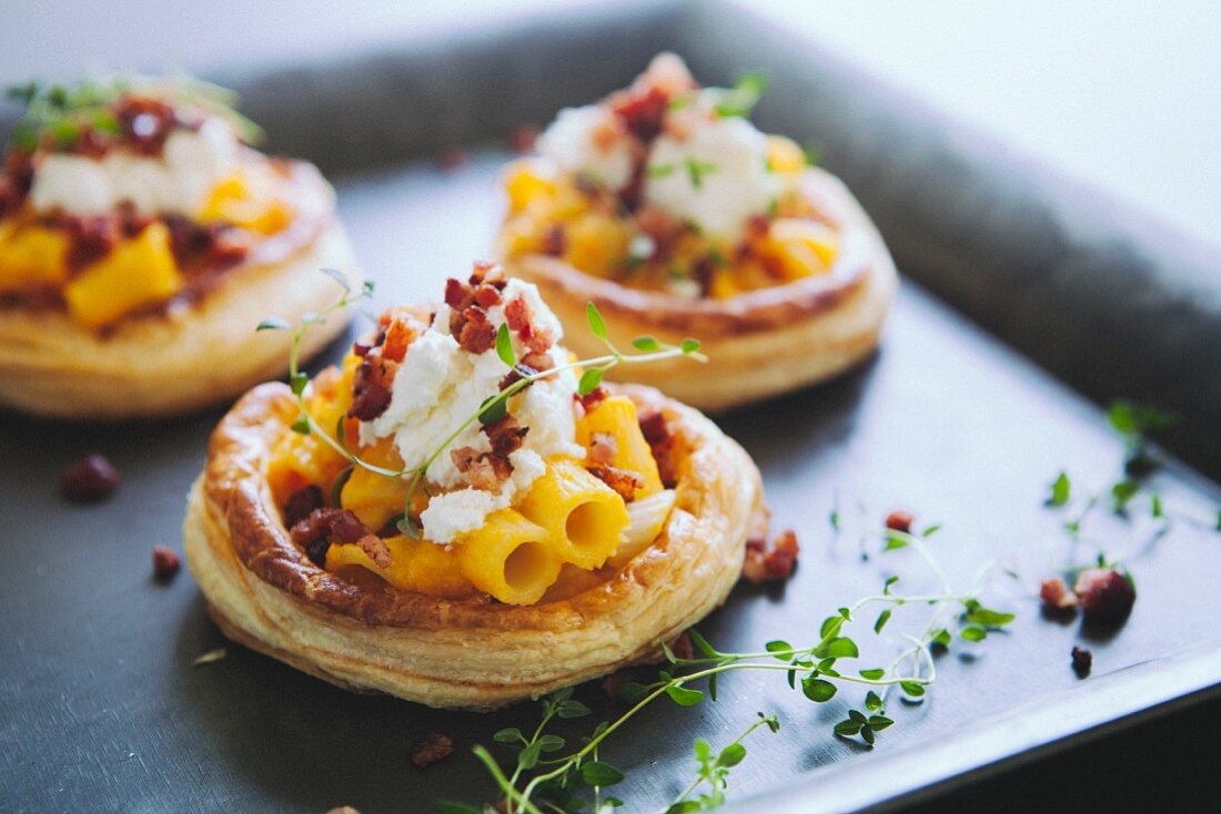 Puff pastry tartlets topped with bacon, ricotta and macaroni