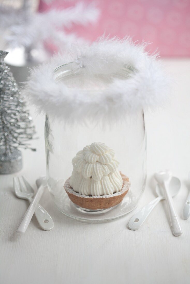 A shortcrust tartlet in a glass decorated with a feather