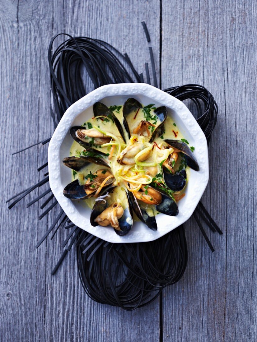 Mussels in a creamy sauce on squid spaghetti