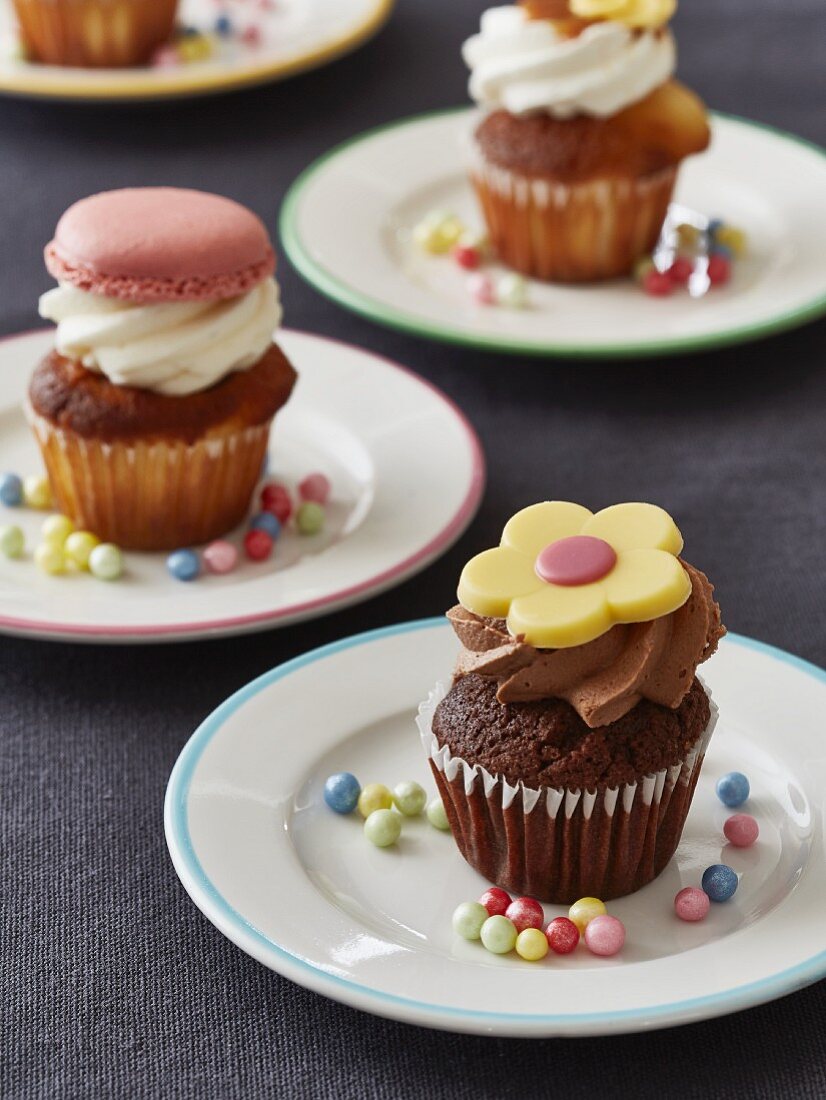 Verschiedene Mini-Cupcakes auf Tellern