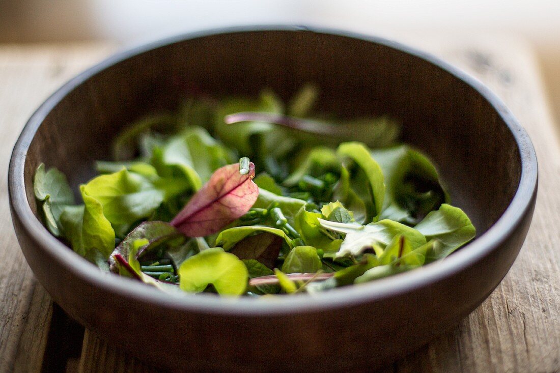 Mixed salad leaves in wooden bowl