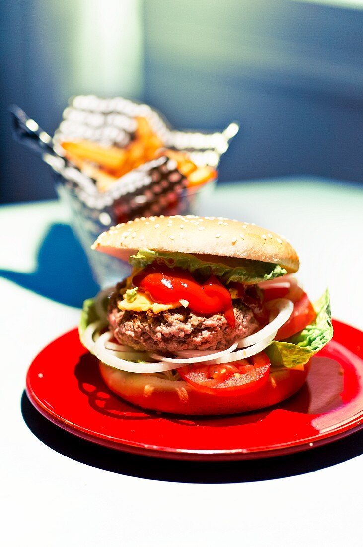 A hamburger with tomatoes and onions on a plate