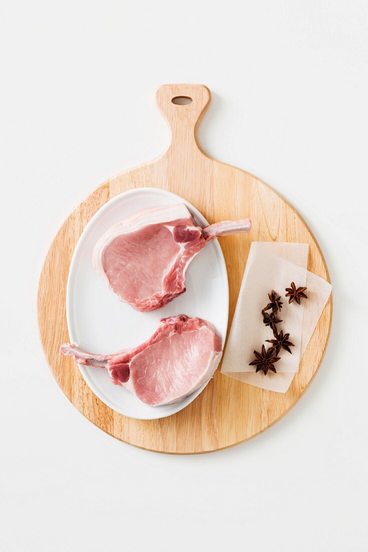 Pork chops and star anise on a chopping board