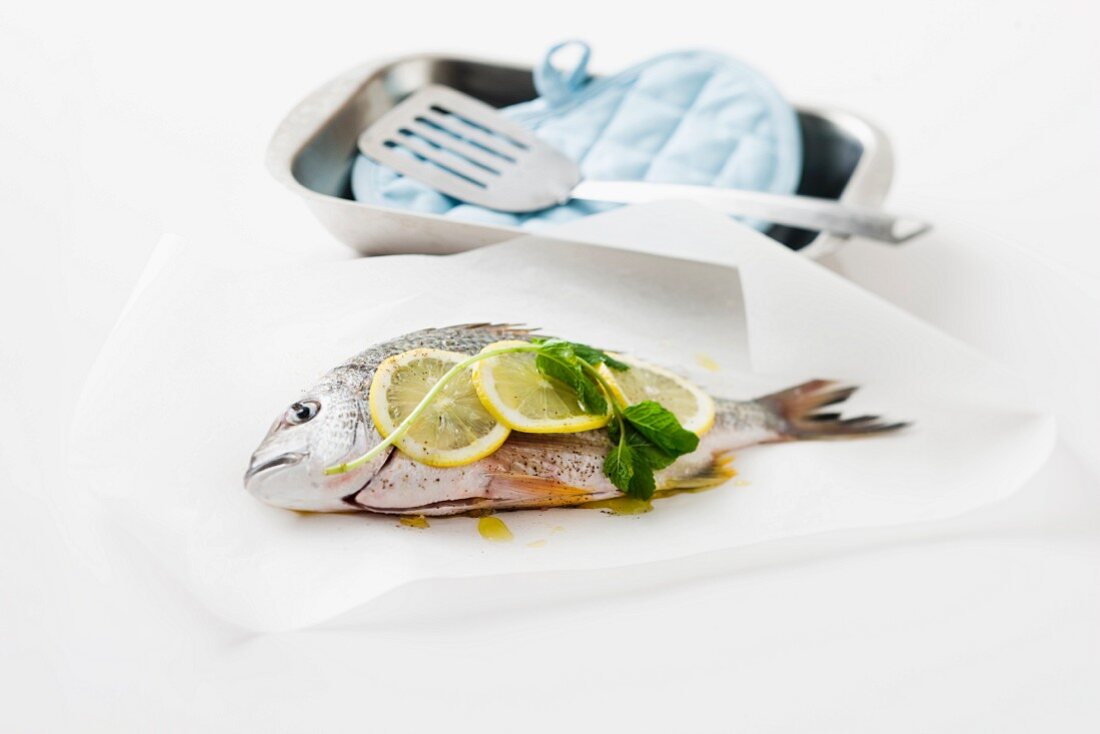 Seabream with lemon slices and basil