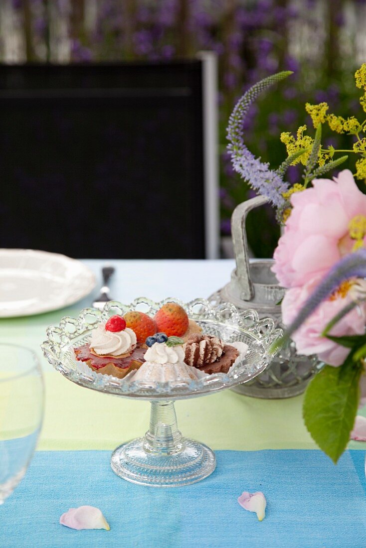 Table set with desserts and flowers in garden