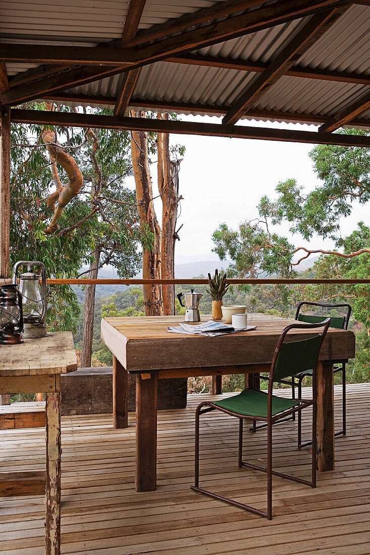 Old table and simple metal chairs wooden terrace