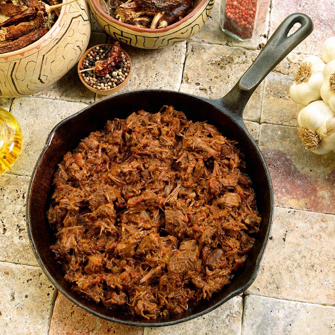 Adobo chili in a cast iron pan, dried chilli peppers, garlic, oil and pepper corns