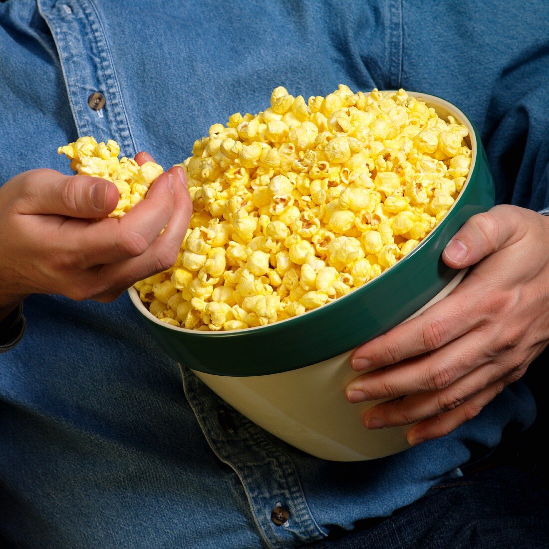 Mann hält eine Schüssel Popcorn