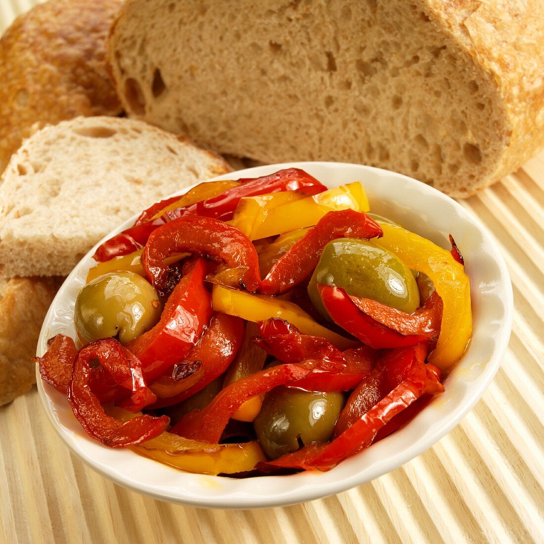 Peperonata (rote und gelbe Paprika, grüne Oliven, Knoblauch) mit Brot