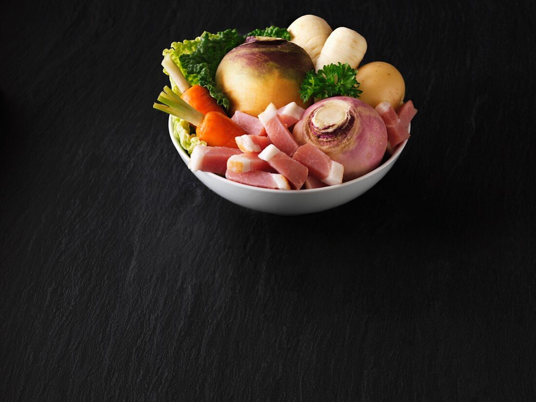 A bowl of fresh vegetables with bacon