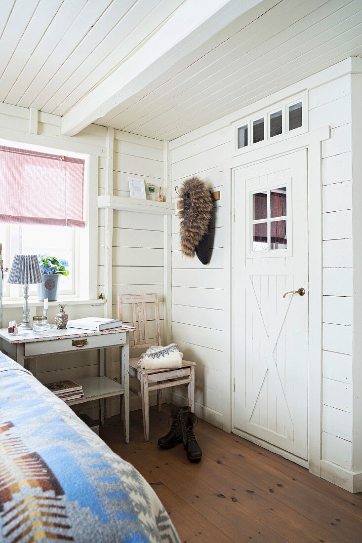 Corner of white, wood-clad bedroom