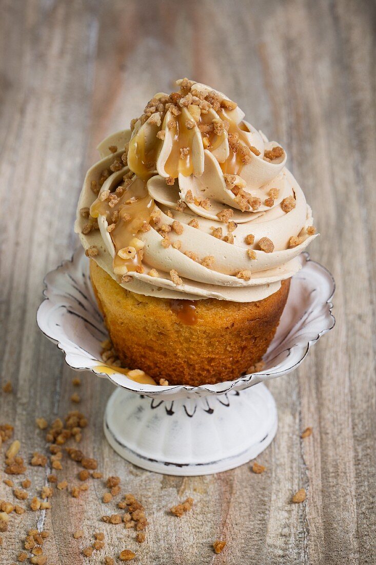 A cupcake topped with buttercream and caramel sauce