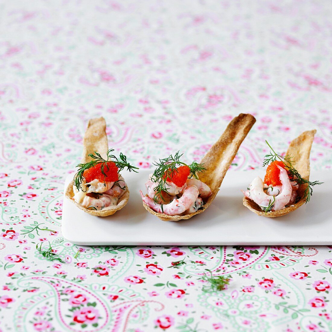 Prawn salad with caviar and dill on baked spoons as spoon canapes