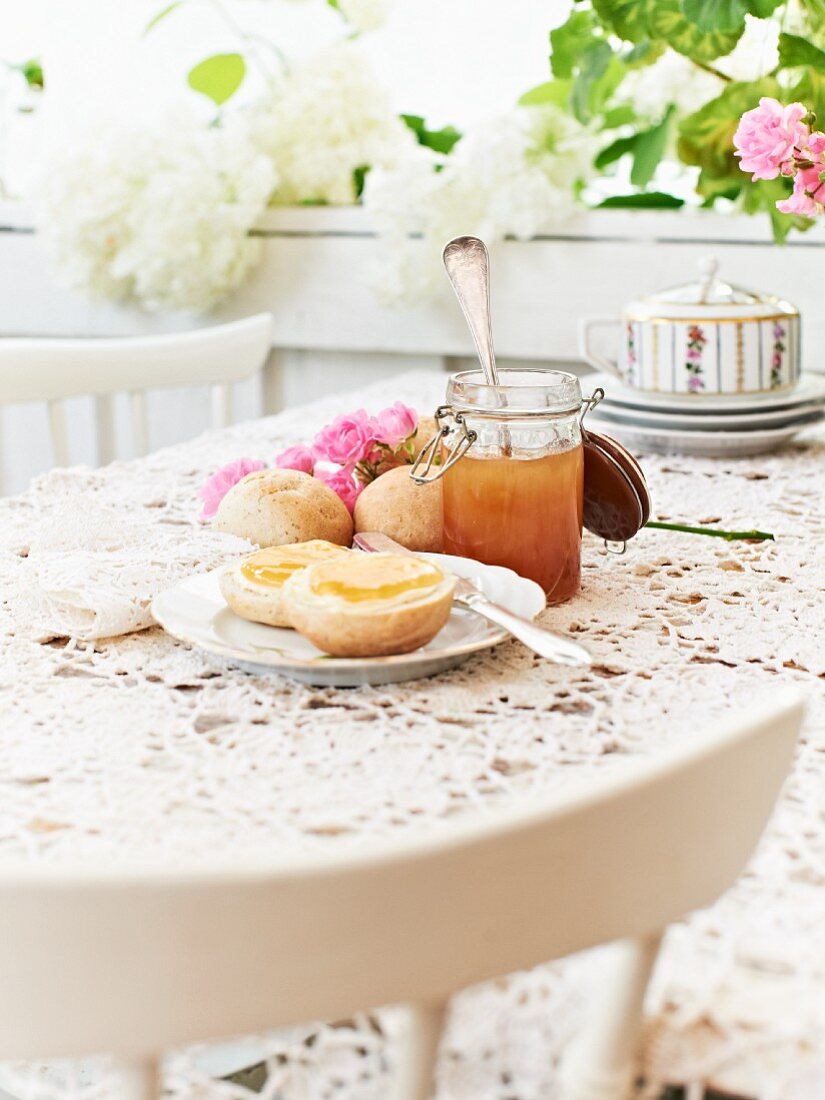 A jar of apple jelly and fresh rolls