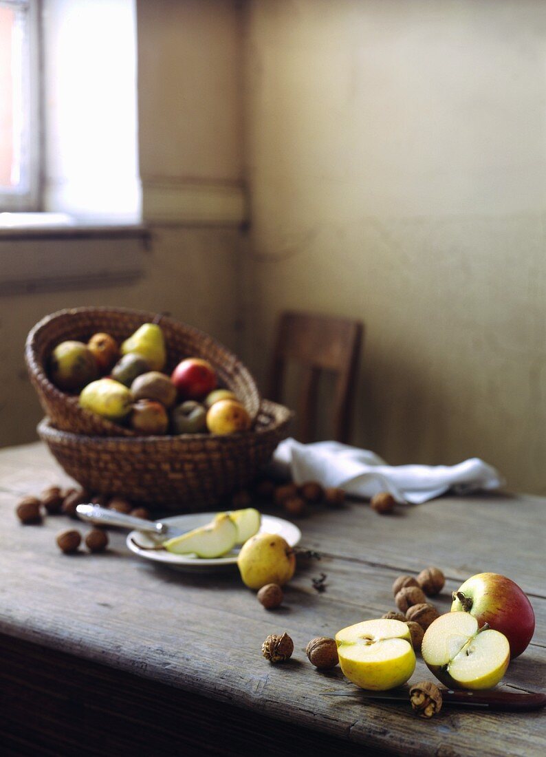A rustic arrangement of apples and nuts on a wooden table