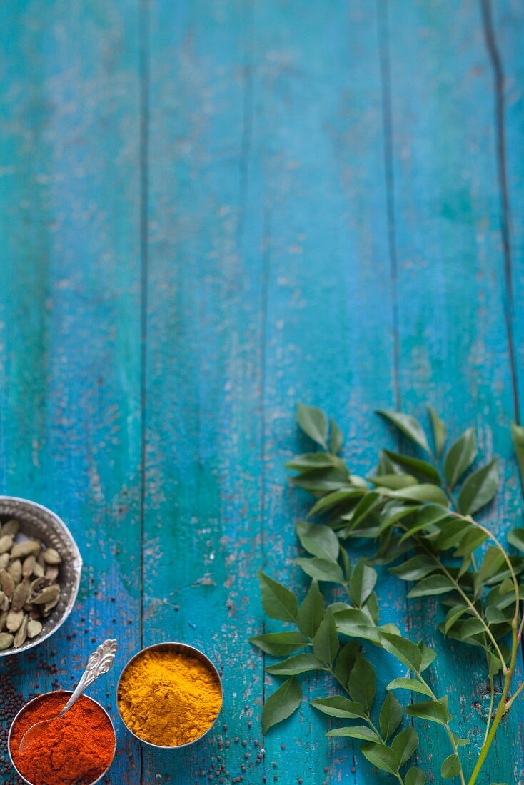 Indian spices on a turquoise blue wooden table
