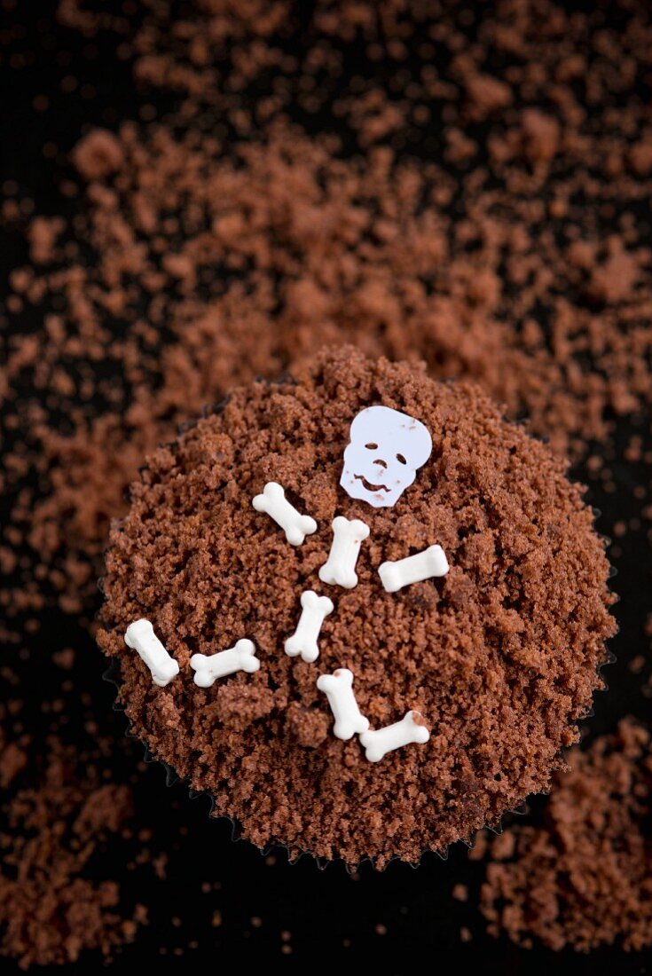 A chocolate cupcake decorated with a skeleton for Halloween