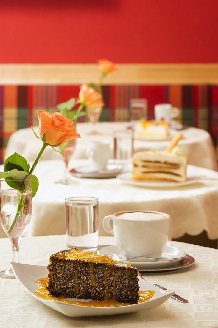 Mohntorte und Kaffee auf gedecktem Kaffeehaustisch