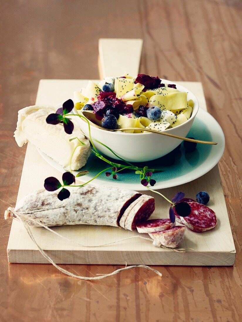 Tagliatelle with chutney and poppyseeds served with goat's cheese and salami