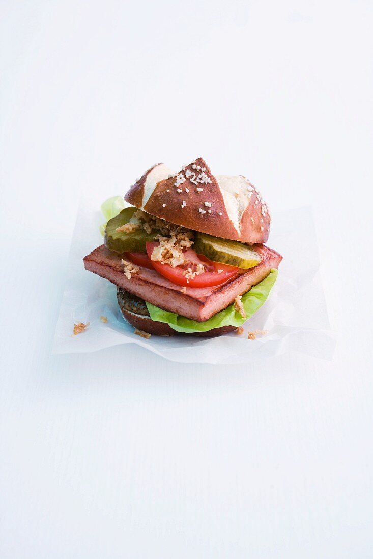 A lye roll with Leberkäse (beef and pork meatloaf), tomatoes and gherkins