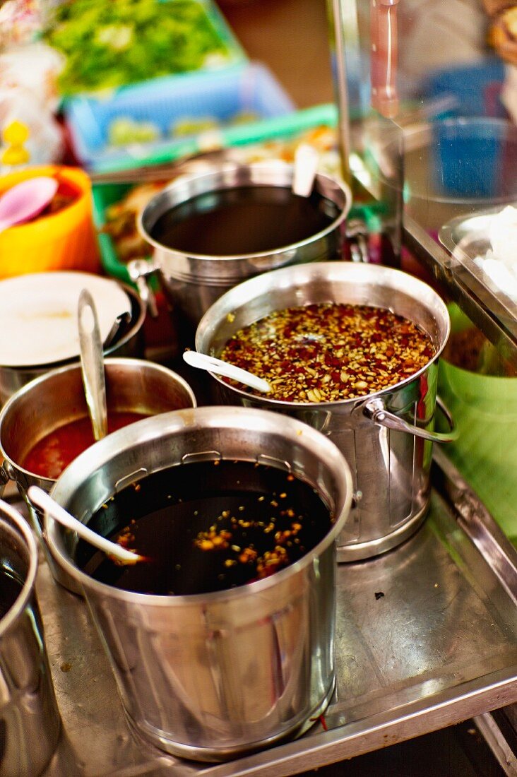 Various sauces in buckets at a market in Saigon (Vietnam)