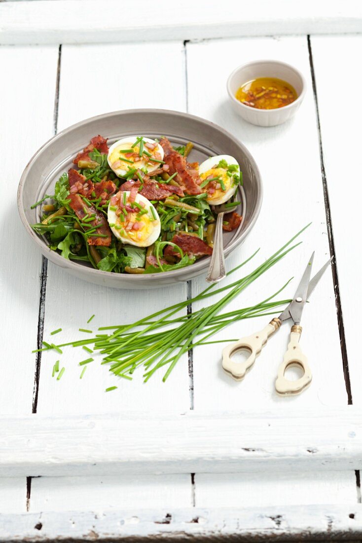 Grüner Bohnensalat mit Rucola, Bacon, Ei, Schnittlauch und Zwiebeldressing