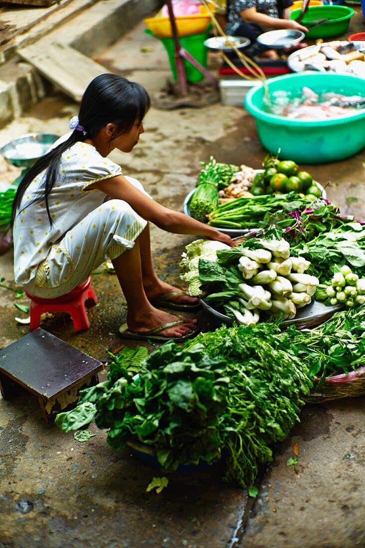 Mädchen verkauft Gemüse auf einem Markt in Saigon (Vietnam)