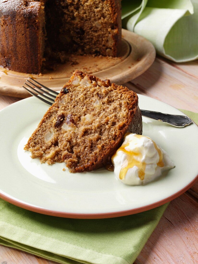 Somerset Apfelkuchen (England), ein Stück auf Teller mit Sahne und Honig