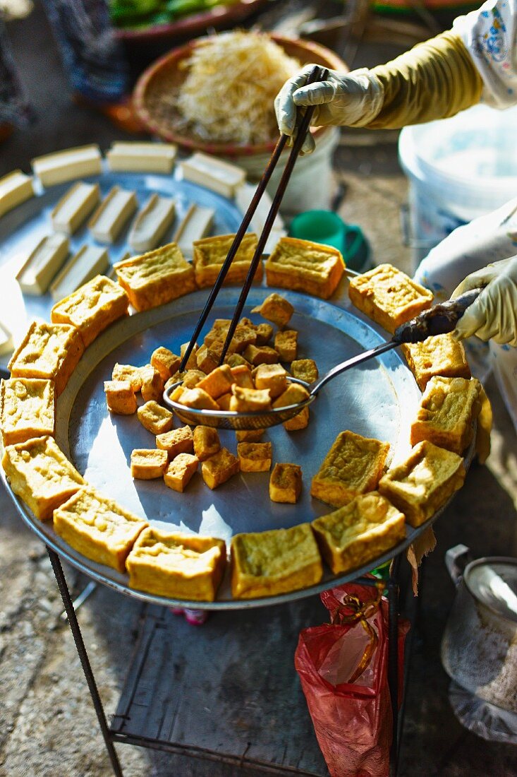 Frau verkauft frittierten Tofu auf Markt in Haiphong, Vietnam