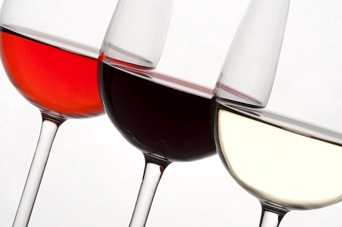 Drei mit unterschiedlichen Weinen gefüllte Weingläser
