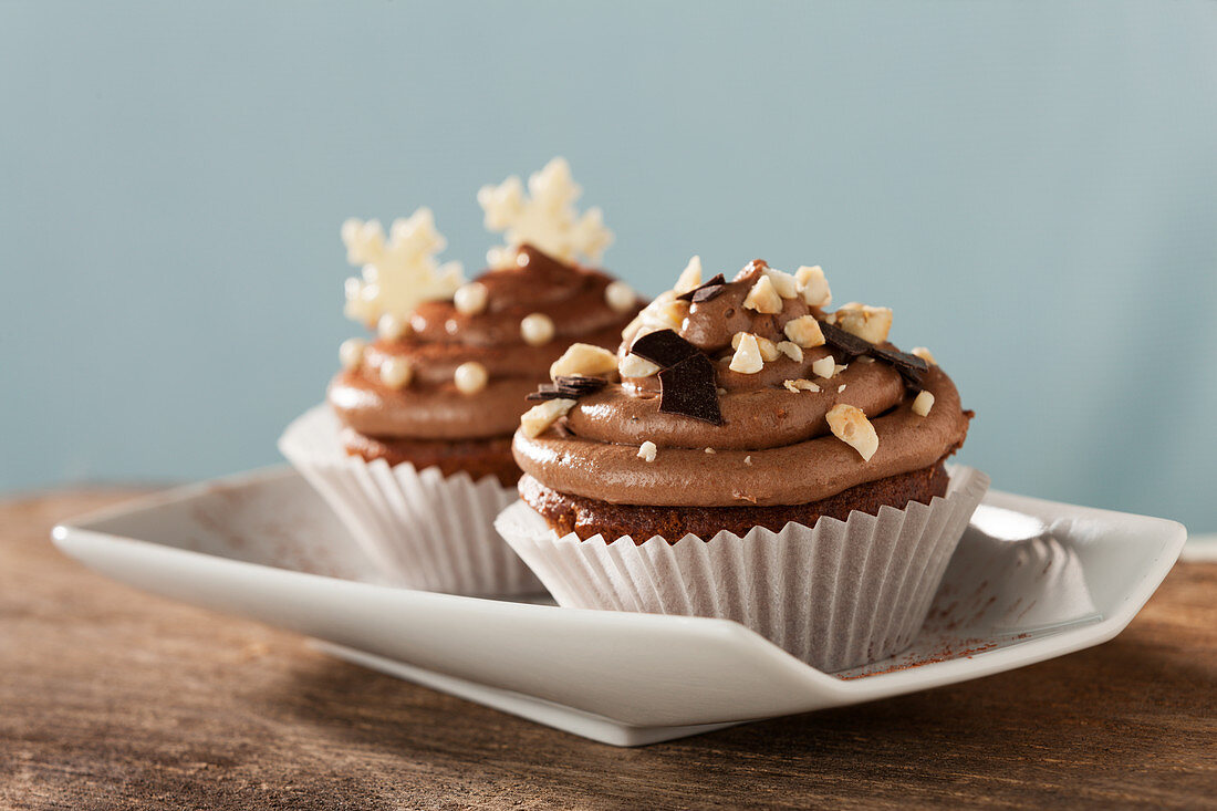 Cupcakes topped with chocolate cream and nuts for Christmas