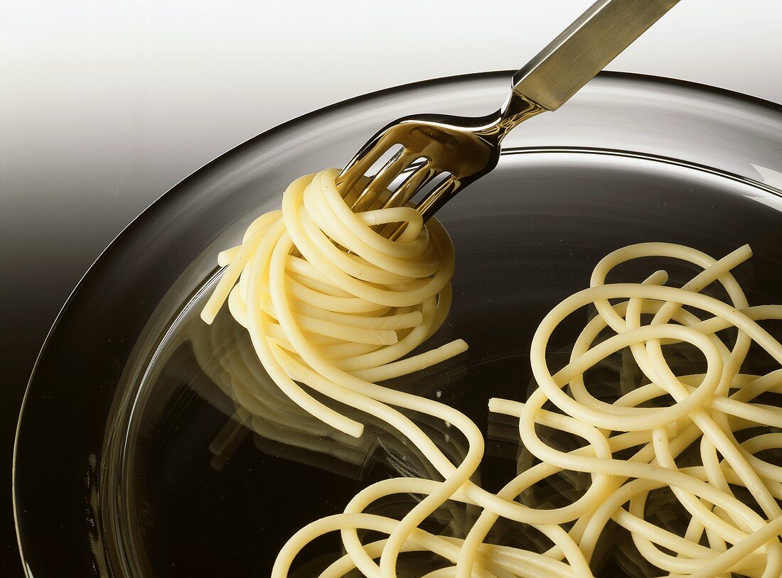 Gekochte Spaghetti mit einer Gabel aufdrehen