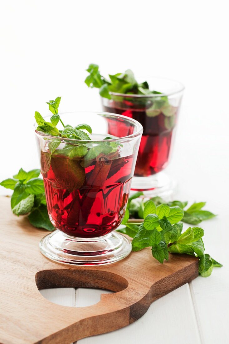 Warm cherry drinks with cinnamon and fresh mint