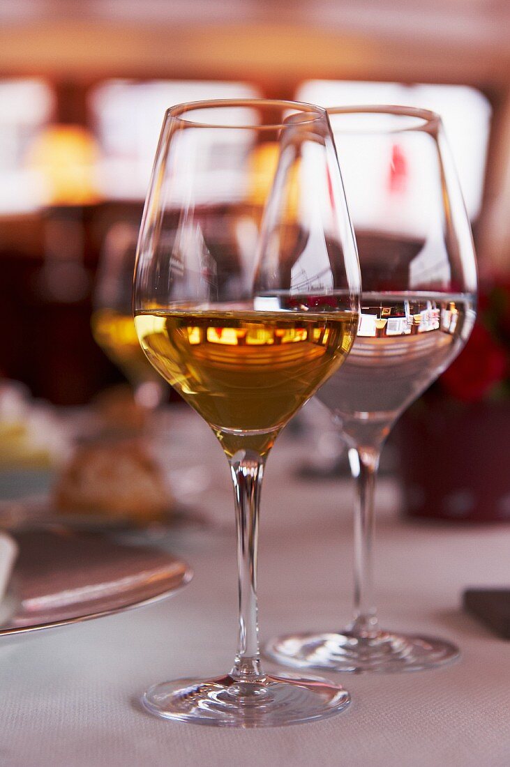 Two glasses of white wine on a table in a restaurant