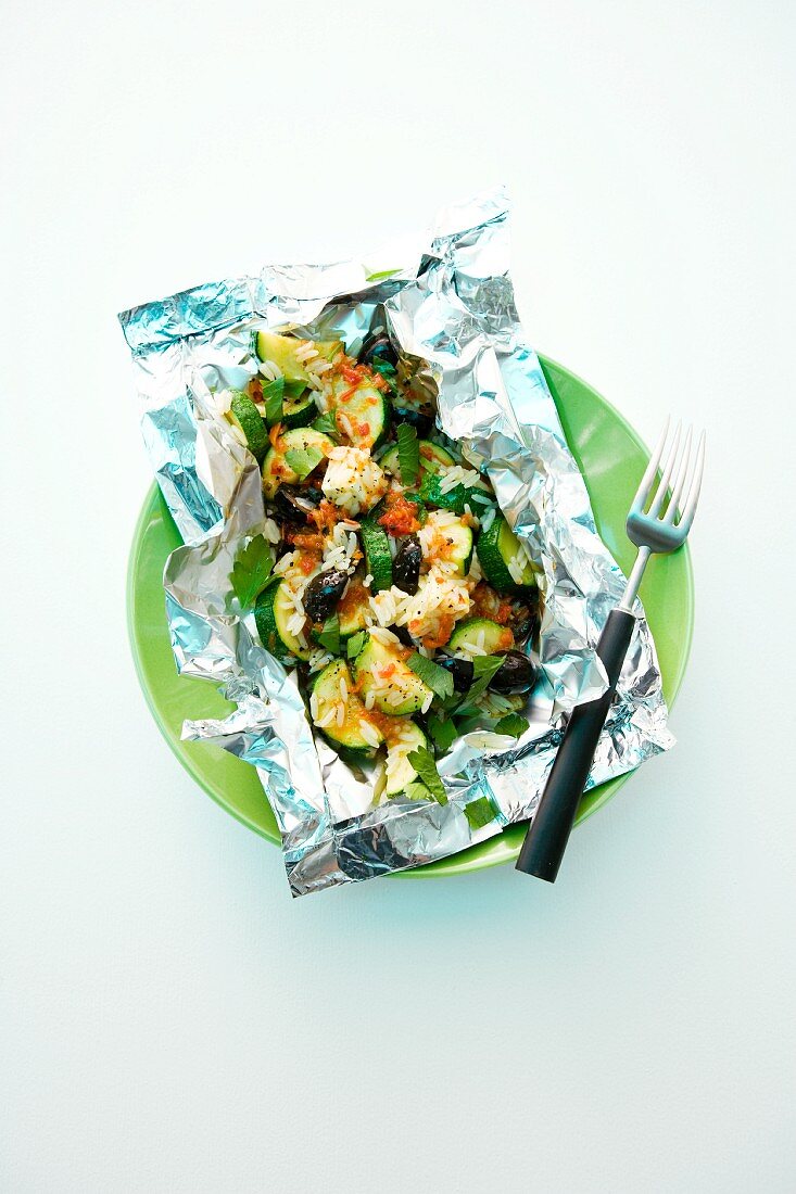 A vegetable parcel with rice and feta in aluminium foil
