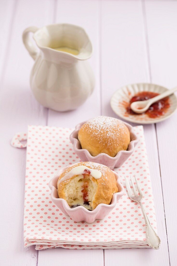 Buchteln in Muffinförmchen mit Vanillesoße und Erdbeermarmelade