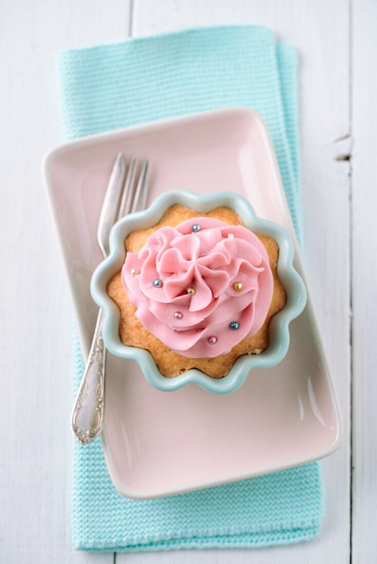 Cupcake mit rosa Buttercreme und Zuckerperlen