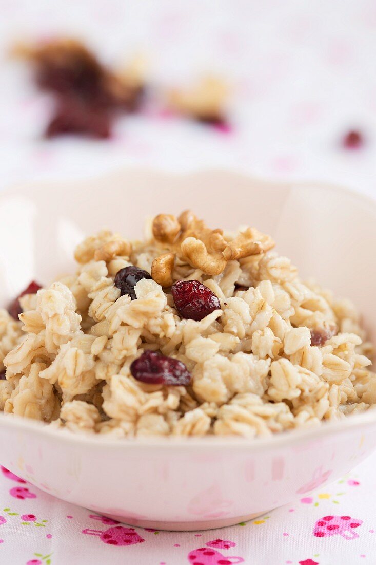 A bowl of oats with nuts and cranberries